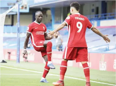  ??  ?? Sadio Mane (L) celebrates with Firmino after scoring one of his goals in the 2-0 defeat of Chelsea yesterday at Stamford Bridge