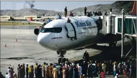  ?? WAKIL KOHSAR — AFP VIA GETTY IMAGES ?? Afghan people climb atop a plane as they wait at the Kabul airport on Monday. Thousands mobbed the airport trying to flee the Taliban’s feared Islamist rule.