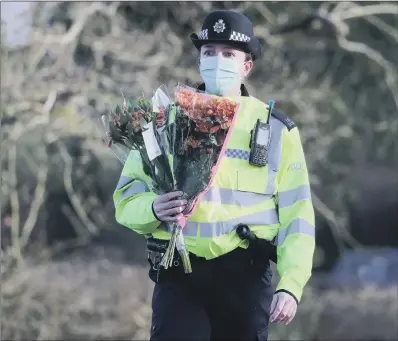  ?? PICTURE: GARETH FULLER/PA. ?? SOMBRE DUTY: A police officer carries flowers brought by a member of the public to the entrance of Great Chart Golf and Leisure in Ashford in Kent, after detectives confirmed that human remains found nearby are those of Sarah Everard, inset, who was originally from York.