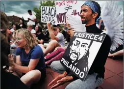  ?? RICHARD TSONG-TAATARII/MINNEAPOLI­S STAR TRIBUNE ?? Protesters gather on June 18 at Silver Lake Village Shopping Center in St. Anthony, Minn. for a memorial rally in honor of Philando Castile. Abdi Iman, of Eden Prairie, was dressed as an angel.