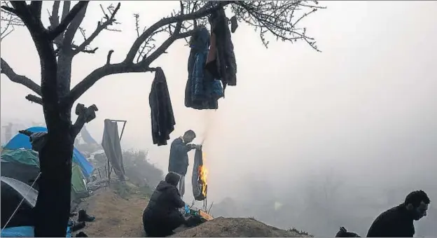  ?? DIMITAR DILKOFF / AFP ?? Un refugiado quemando unos viejos pantalones para calentarse en medio de la niebla que rodeaba ayer el campamento de Idomeni, entre Grecia y Macedonia