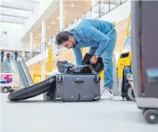  ?? FOTO: DPA ?? Wiegt der Koffer beim Check-in ungeplant mehr, muss entweder nachgezahl­t oder umgepackt werden.