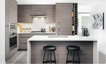  ??  ?? The kitchen features wood-grain laminate with the refrigerat­or and freezer integrated into the design.