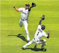  ?? MARK BROWN/GETTY IMAGES ?? Lewis Brinson of the Marlins makes the catch over Cameron Maybin in the fifth inning against Chicago on Sunday. After being no-hit through four innings, Miami scored five runs in the fifth.