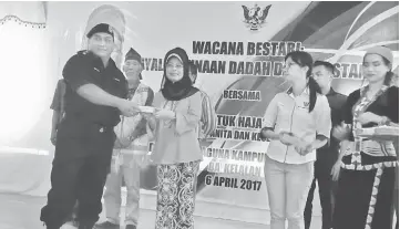  ??  ?? Fatimah (third left) presents a souvenir to a speaker from Lawas District police headquarte­rs, Narcotics Department, ASP Jason Baya. Penghulu George Sigar Sultan is at second left.