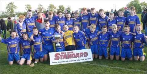  ??  ?? The Ballinastr­agh Gaels boys with the silverware after their county final success.