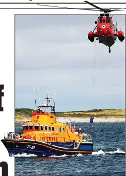  ??  ?? Team work: A lifeboat and Sea King helicopter