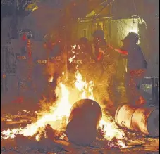  ?? AP ?? ANGER GROWS: Cops advance to push back protesters seeking firm government action over the blast, in Beirut on Thursday.