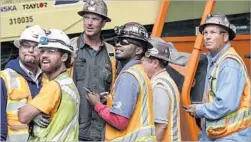  ??  ?? WORKERS AWAIT the arrival of Angeli, which tunneled from Little Tokyo to Bunker Hill. “It sounds like King Kong behind the gates,” one joked.