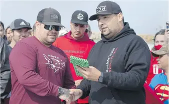  ?? THE CANADIAN PRESS ?? Chief Mike Sack, right, presents a lobster licence and trap tags to Randy Sack in Saulniervi­lle, N.S., last September after Sipekne’katik fishers launched a self-regulated fishery.