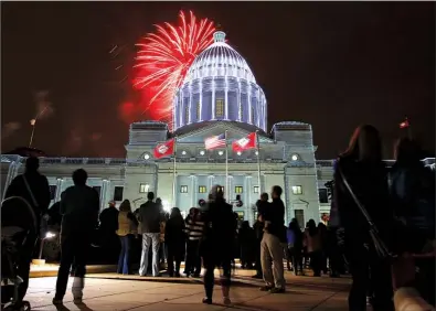  ?? Arkansas Democrat-Gazette/STEPHEN B. THORNTON ?? Spectators take in fireworks exploding over the state Capitol after lights on the building were turned on Saturday evening at the end of the Big Jingle Jubilee Holiday Parade.