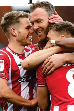  ?? REX ?? Hugs all round: McDonald (centre), celebrates his goal with Exeter City team-mates Harry Kite (left) and Archie Collins
