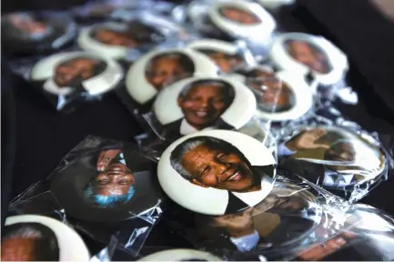  ?? (Reuters) ?? PINS DEPICTING former South African President Nelson Mandela are displayed for sale at a memorial service held by the African National Congress.