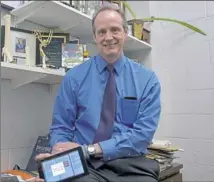  ?? Pam Panchak/Post-Gazette ?? John Pollock, a professor of biology at Duquesne University, shows his new app that teaches children — and adults — about concussion­s.