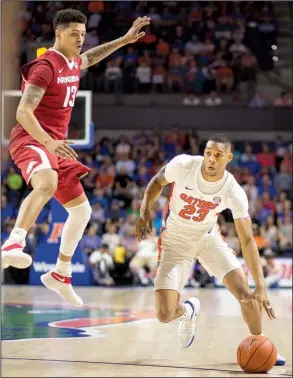  ??  ?? AP/RON IRBY
Florida’s Justin Leon (right) dribbles past Arkansas’ Dustin Thomas during Wednesday night’s game at Gainesvill­e, Fla. The Gators won 78-65, ending the Razorbacks’ five-game winning streak.