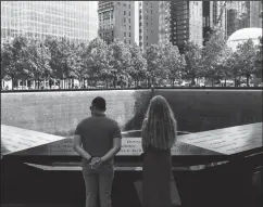  ?? ANGELA WEISS/AFP VIA GETTY IMAGES/TNS ?? A couple stands before the National September 11 Memorial, marking the site of the south tower at the World Trade Center in New York, on Wednesday. The remains of two more victims of 9/11 have been identified, thanks to advanced DNA technology, New York officials announced on Tuesday, just days before the 20th anniversar­y of the attacks.