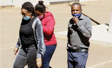  ?? — Picture: Lee Maidza ?? A police detective (right) escorts suspected cocaine dealers at the Harare Magistrate­s Court yesterday.