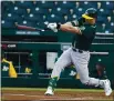  ?? ROSS D. FRANKLIN — THE ASSOCIATED PRESS ?? Oakland A’s Seth Brown breaks his bat as he connects for a run-scoring double against the Cincinnati Reds during the first inning of a spring training game on March 13.