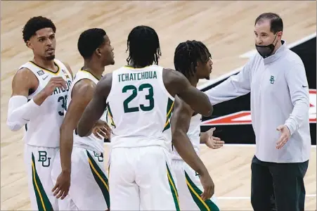  ?? CHARLIE RIEDEL / AP ?? Baylor coach Scott Drew, right, talks to his players during the Bears’ second-round Big 12 Conference Tournament game against Kansas State Thursday in Kansas City, Mo. After cruising through most of the year undefeated, Baylor has gone 4-2 over its last six games and could have trouble living up to its No. 1 seed in the NCAA Tournament’s South Regional.