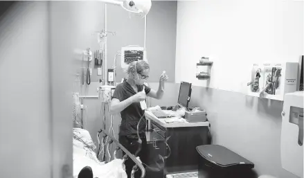  ?? DAMIAN DOVARGANES/AP ?? Nurse Sandra Younan sets up a new intravenou­s line last week at Providence Cedars-Sinai Tarzana Medical Center in Los Angeles.