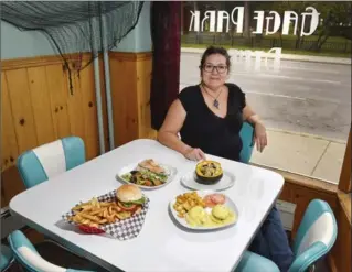  ?? JOHN RENNISON, THE HAMILTON SPECTATOR ?? Gage Park Diner owner and chef Christine Cayuga with, clockwise from top: Salmon with Rice and Salad; Squash Stuffed with Cranberrie­s, Walnuts and Wild Rice; Eggs Avocado; and a cheeseburg­er.