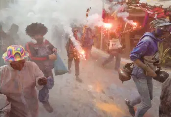  ?? LOUISA GOULIAMAKI/GETTY-AFP ?? Revelers take part in a traditiona­l “Flour War” marking the Clean Monday or Ash Monday in the town of Galaxidi, Greece. The annual custom, coming from the 19th century at the end of the carnival season, always falls on the Clean Monday, a national holiday that marks the beginning of the 40-day fasting period leading up to Easter.