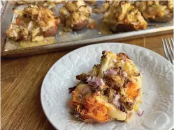  ?? (Gretchen McKay/Pittsburgh Post-Gazette/TNS) ?? Sweet potatoes stuffed with cheesy, roasted cauliflowe­r make a quick and easy vegetarian dinner.