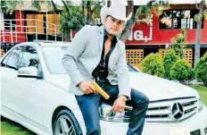  ??  ?? Javier Reyes, en una publicació­n de redes sociales, donde aparece con el arma dorada y el vehículo Mercedes Benz que utilizaba en sus videos.