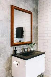  ??  ?? Style tip Soften an industrial looking bathroom with natural elements. Sarah has done this with a wooden mirror and greenery.