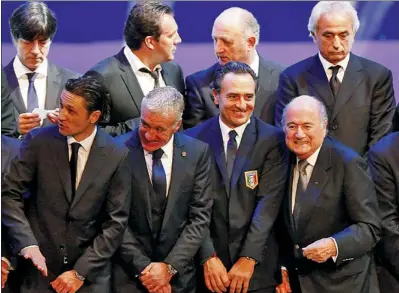  ?? SERGIO MORAES/REUTERS ?? FIFA president Sepp Blatter (bottom row, right) smiles alongside Italy’s coach, Cesare Prandelli (bottom row, second right), and France’s coach, Didier Deschamps, (bottom row, second left) during their group photo after the draw for the 2014 World Cup...