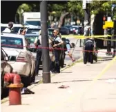  ?? ASHLEE REZIN GARCIA/SUN-TIMES ?? Police investigat­e in the 300 block of North Central after a 9-year-old boy and his 27-year-old mother were shot Wednesday afternoon.