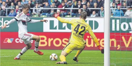  ?? FOTO: AFP ?? Wenn nichts geht, trifft Thomas Müller: Bayerns Angreifer lässt Bremens Keeper Felix Wiedwald ( rechts) beim Siegtor keine Chance.