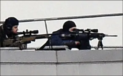  ??  ?? Surrounded: Police snipers on a roof at the industrial estate in Dammartin-en-Goele