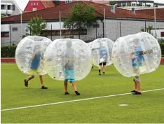  ?? Fotos: Claudia Deeney ?? Auch Jonglieren kann man am Gymnasium lernen. Und beim Bubble Fußball konnte man als Spieler schon mal Überblick und Gleichgewi­cht verlieren. Trotzdem und auch trotz der großen Hitze probierten viele Jugendlich­e den Spaß aus.