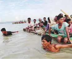  ?? Reuters ?? Rohingya refugees pull a raft as they cross the Naf River to reach to Bangladesh from Myanmar yesterday.