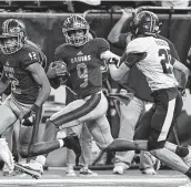  ?? Jerry Baker / Contributo­r ?? Beaumont West Brook quarterbac­k La'Ravien Elia , center, looks for an opening as Tompkins’ Pryce Powell closes in Saturday night at NRG Stadium.