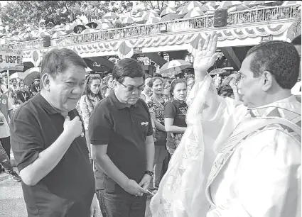  ?? / ARNI ACLAO ?? ■ SINULOG 2019 BUKAS NA: Si Msgr. Roberto Alesna nanalangin kanila ni Cebu City Mayor Tomas Osmeña (wala) ug Bise Mayor Edgardo Labella (tuo) human sa misa nga nagtimaan sa pagbukas sa Sinulog 2019. Sila si Osmeña ug Labella mag-atbang sa eleksyon sa Mayo pagkamayor.