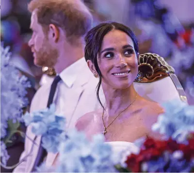  ?? ?? In the spotlight: Meghan with Harry at a reception in Nigerian capital Abuja on Saturday