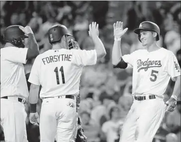  ?? Jae C. Hong Associated Press ?? COREY SEAGER (5), being congratula­ted by Logan Forsythe after a home run last June at Dodger Stadium, followed up his rookie-of-the-year season by hitting .295 with 22 home runs and an .854 OPS.