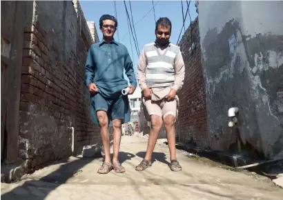  ?? AFP ?? Kot assadullah residents basharat ali and Naveed show their deformed legs allegedly caused by environmen­tal factors and polluted groundwate­r. —