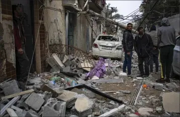  ?? PHOTOS BY FATIMA SHBAIR — THE ASSOCIATED PRESS ?? Palestinia­ns look at the destructio­n after an Israeli airstrike in Rafah, Gaza Strip, on Friday.