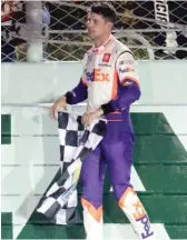  ?? WILFREDO LEE/AP ?? Denny Hamlin claims the checkered flag after winning the NASCAR race Sunday.