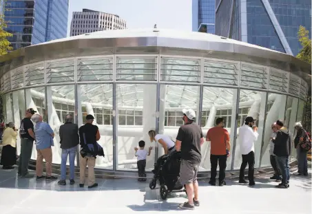  ?? Paul Chinn / The Chronicle ?? Visitors at the transit center’s grand opening peer down into the oculus from the roof, which is braced by the two cracked beams.