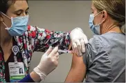  ?? JIM NOELKER / STAFF ?? Premier Health pharmacist Amanda Deskins gives a COVID-19 shot to Miami Valley Hospital emergency room physician Dr. Cathy Marco.
