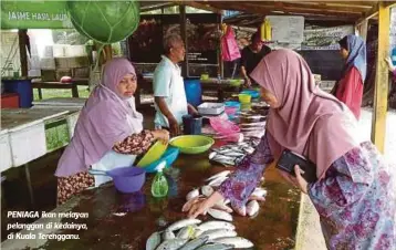  ?? Rahmat Wahab ?? PENIAGA ikan melayan pelanggan di kedainya, di Kuala Terengganu. Selepas ikan itu dijual kepada peruncit pada RM7 sekilogram menyebabka­n mereka menjualnya sehingga RM10 sekilogram”