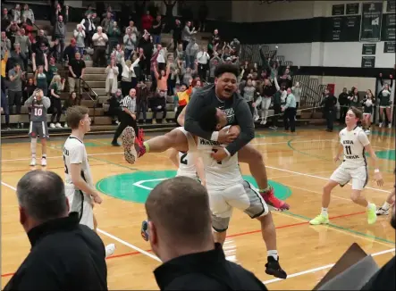  ?? TIM PHILLIS — FOR THE MORNING JOURNAL ?? Elyria Catholic players converge on Edward Wright after a 58-56win over Crestwood in a Division III district semifinal at Bedford. Wright