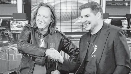  ?? Richard Drew / Associated Press ?? T-Mobile CEO John Legere, left, and Sprint CEO Marcelo Claure will pursue federal approval of the T-Mobile-Sprint merger.