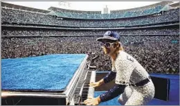  ?? Terry O’Neill Getty Images ?? ICONIC IMAGERY Elton John performs at Dodger Stadium in this 1975 photo by Terry O’Neill.