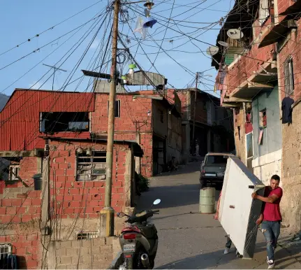  ?? ?? Habitantes del barrio Catia, uno de los más pobres de Caracas, trasladan una cama