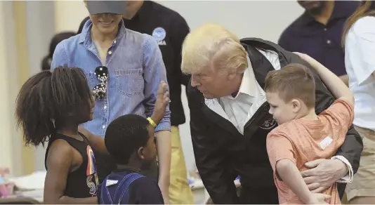 ?? AP PHOTOS ?? CHIEF CONCERN: President Trump distribute­s aid, left, at a church in Pearland, Texas, yesterday after meeting children, below, at the NRG Center in Houston.